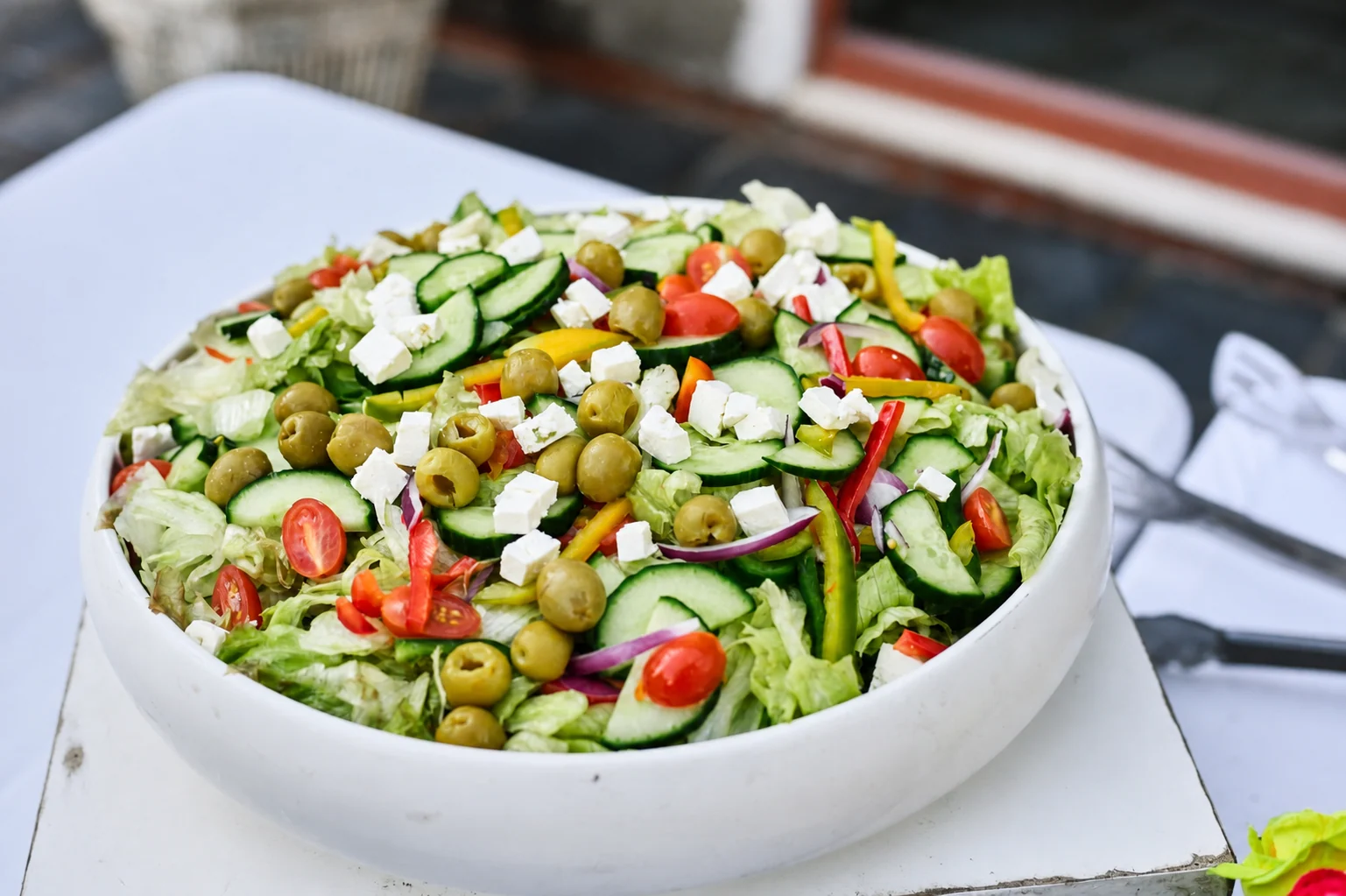 Large freshly prepared salad with cucumber, tomato, feta and olives