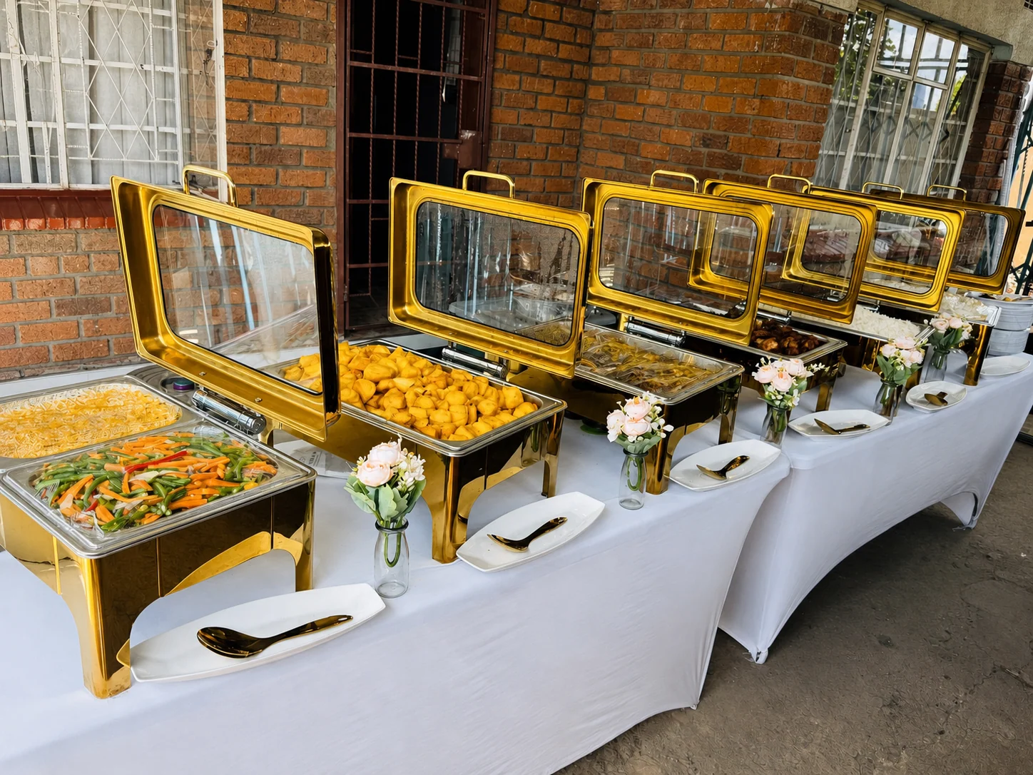 Gold chafing dishes arranged for an outdoor buffet