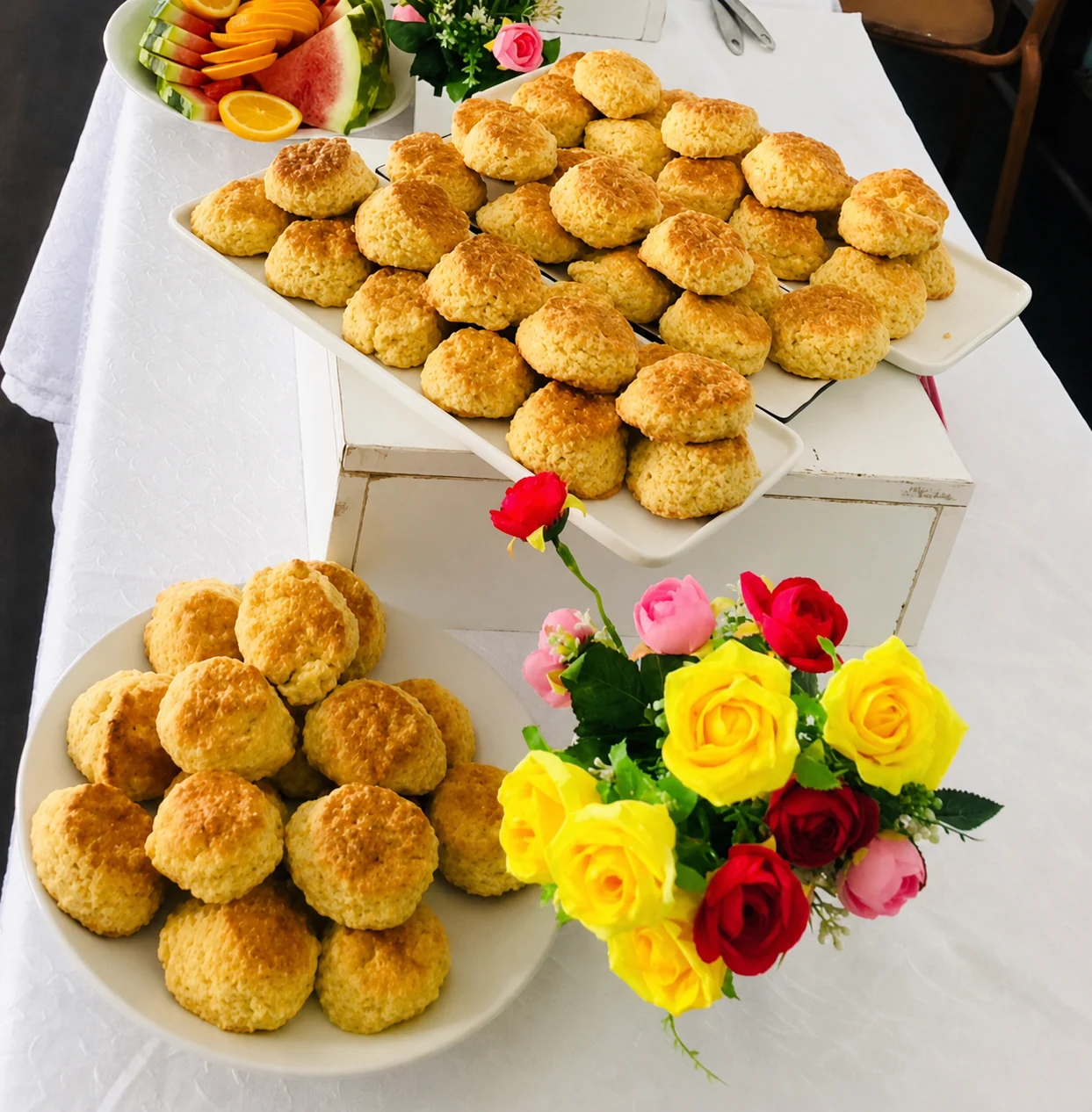 Golden savoury pastries displayed with fruit and flowers