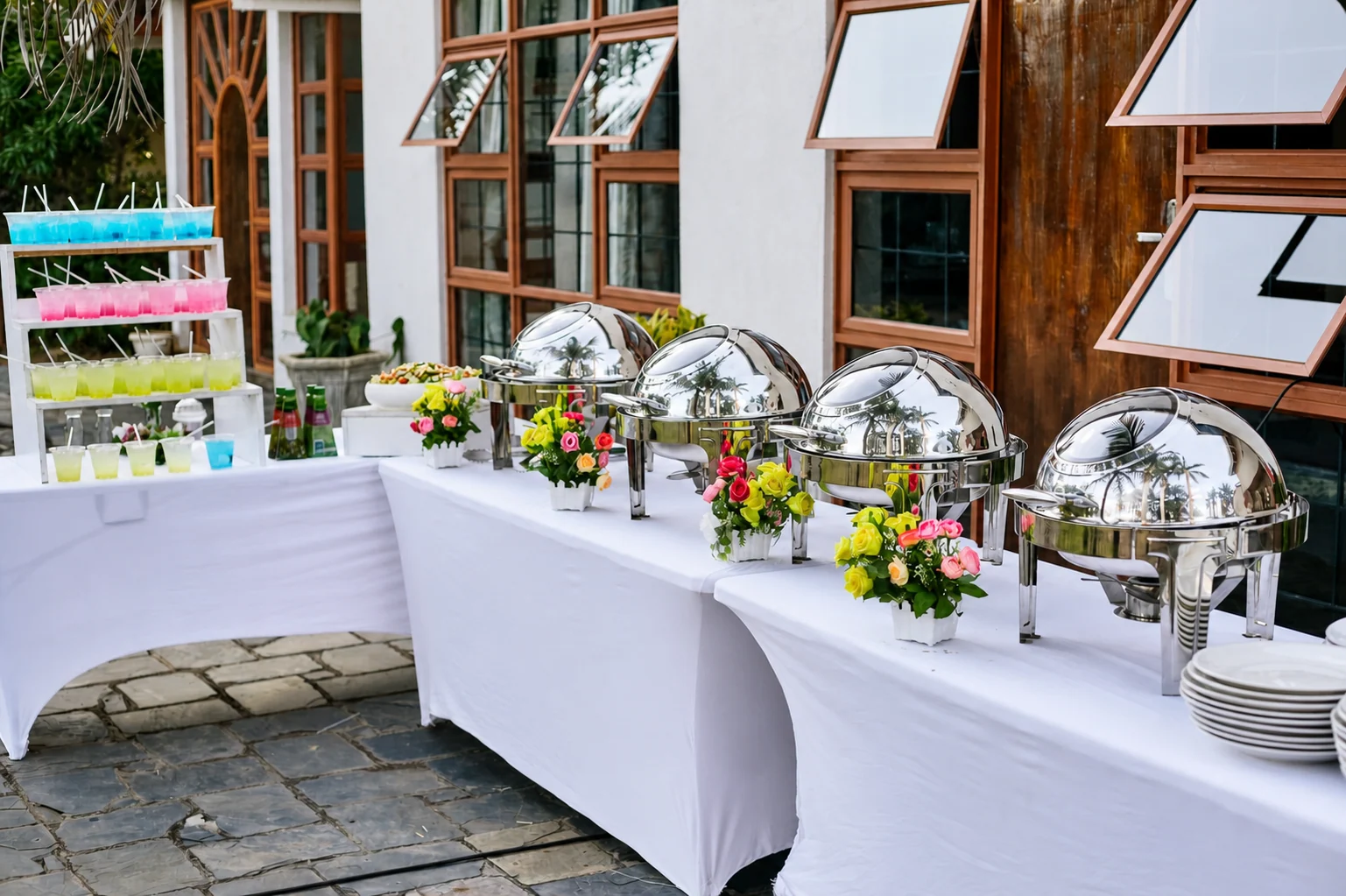 Elegant silver buffet service with flowers and colourful drinks